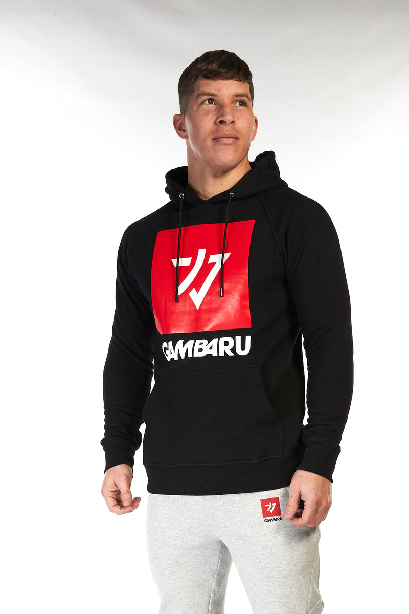 Man wearing unisex black cotton hoodie (hoody) with big red Gambaru Fightwear logo on the front