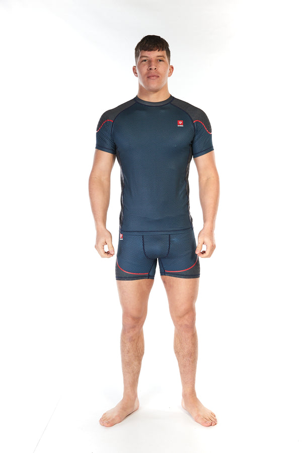 Man wearing short sleeve mid-blue unisex training top with piping across the upper shoulders