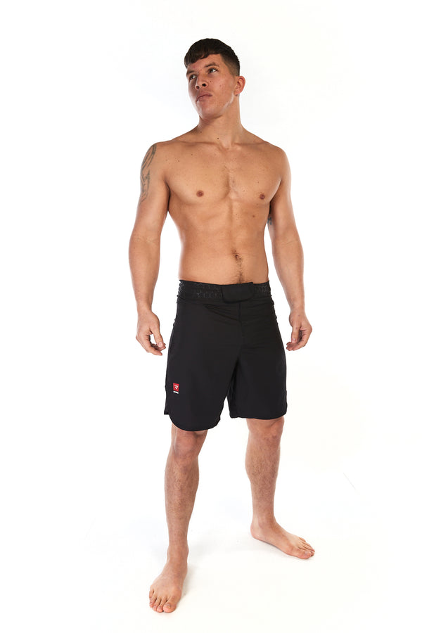 Man wearing black MMA training shorts with small Gambaru Fightwear logo on the right leg
