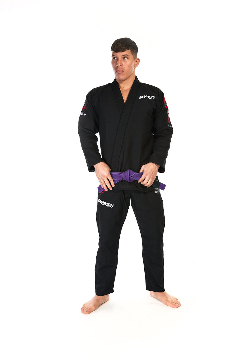 Man wearing unisex fightwear gear in black with white Gambaru Fightwear logo on chest and right thigh